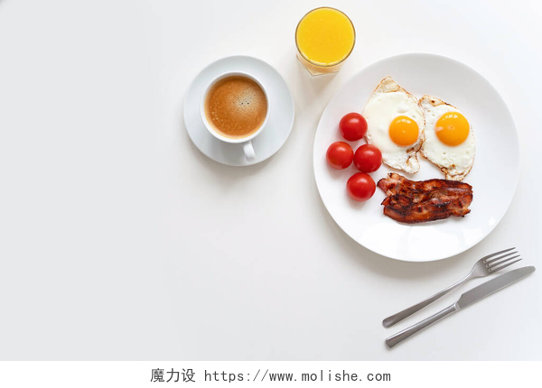 俯拍桌子上的早餐美式早餐,两个鸡蛋,咸肉,西红柿,咖啡和橙汁放在白桌上.顶部视图。复制空间.